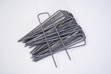 Image of a stack of weed barrier fabric staples from Howell Pathways.