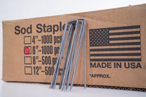 Image of six-inch sod staples leaning up against the box.
